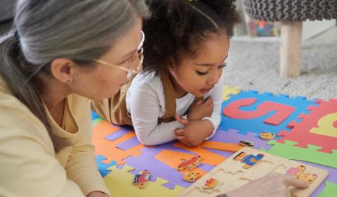 A woman and child playing with a puzzle image